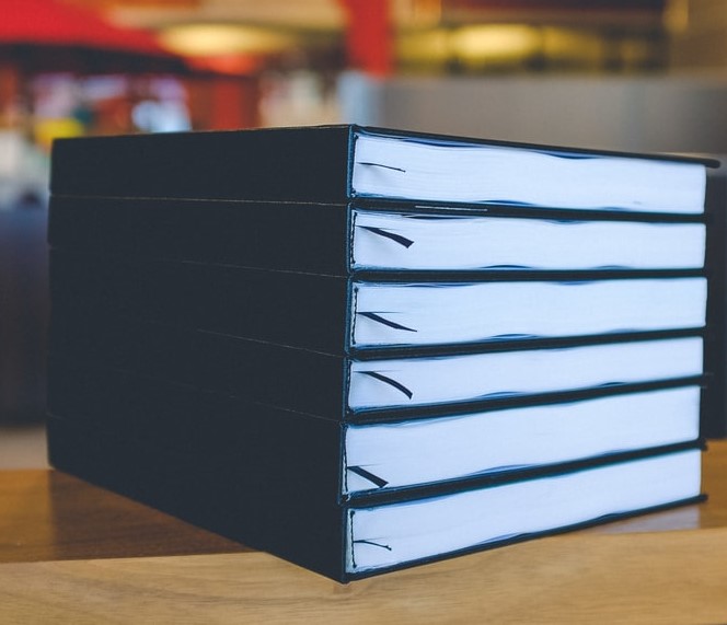 Blue hardbound books on wooden table