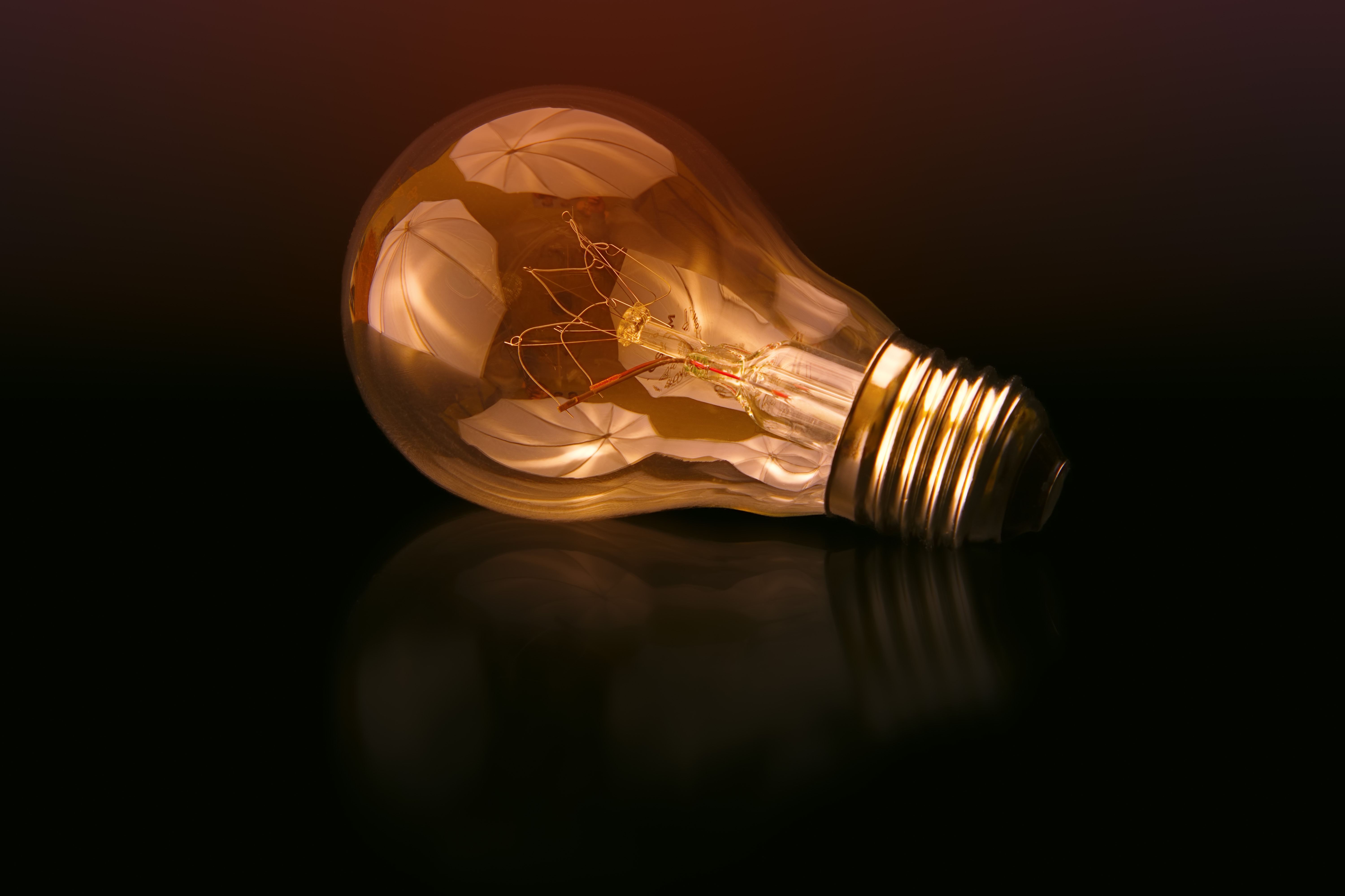 Illuminated lightbulb on side dark background