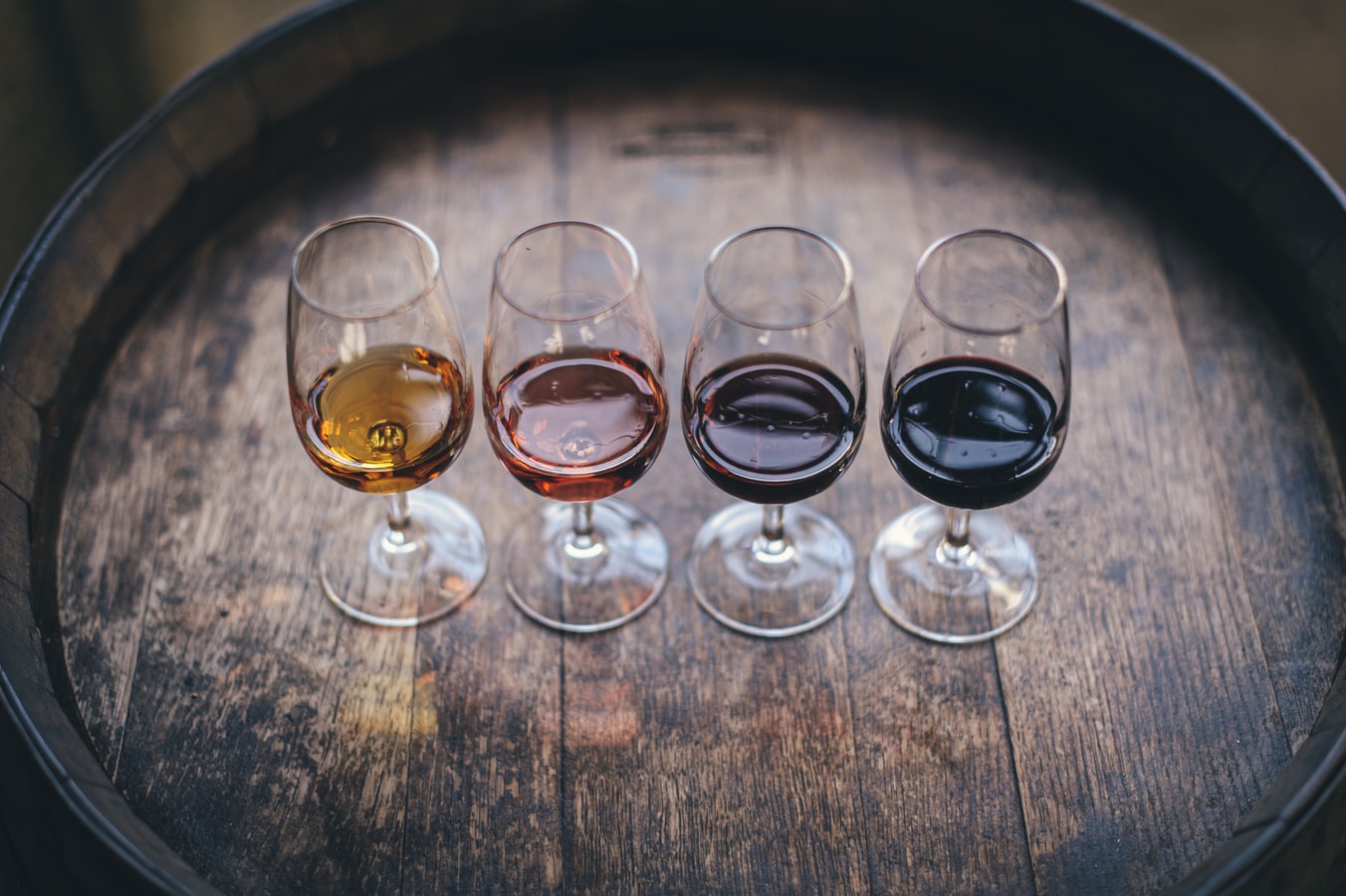Flight of wine in small glasses on wine barrel