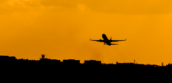 A sillhouette of an airplane taking off at sunset