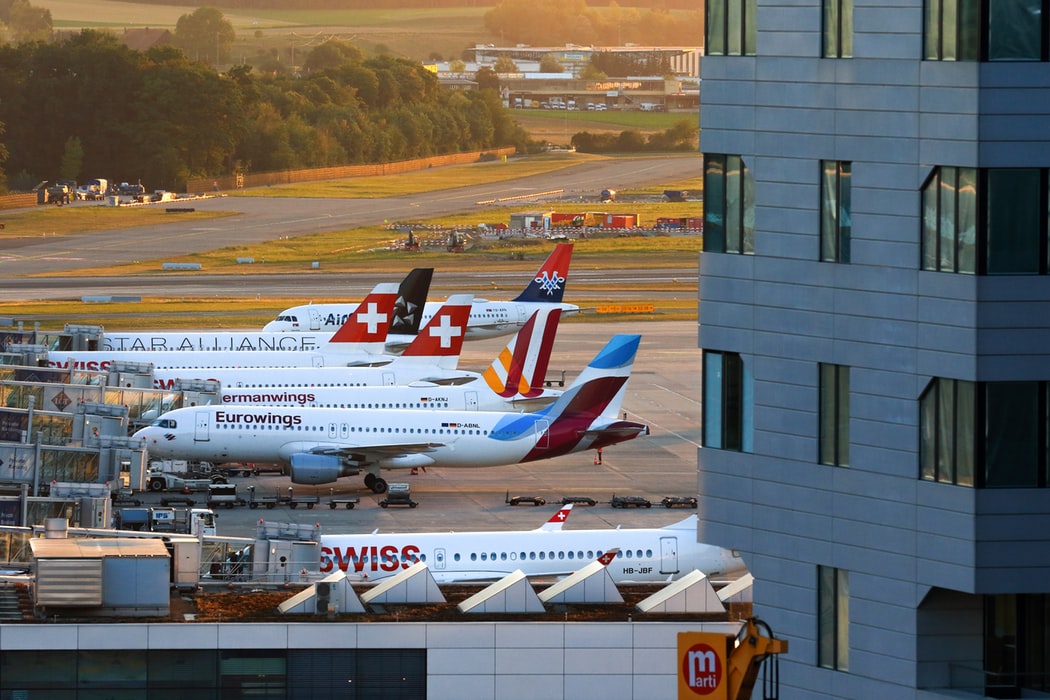 Different planes lined up at airport gates