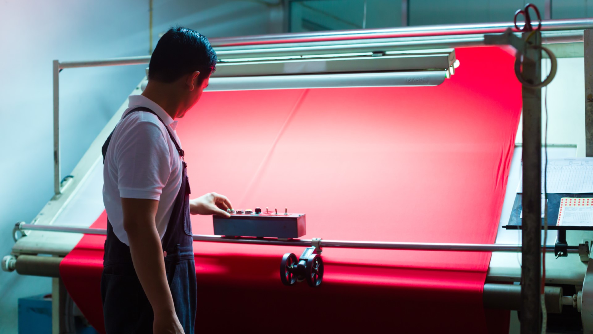 Textile worker inspecting textile and textile machine