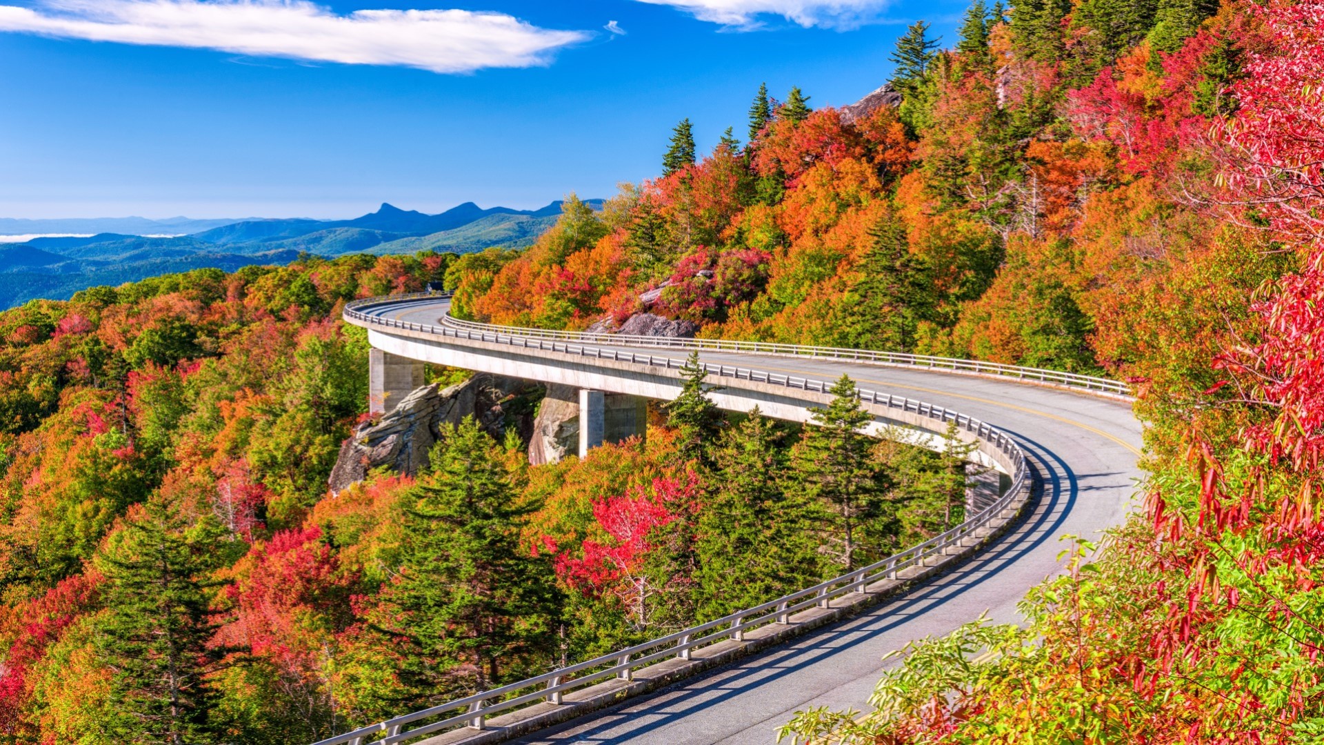 Linn Cove Viaduct in North Carolina in the foreground with fall foliage in the mountains
