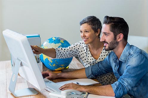 couple at computer with globe