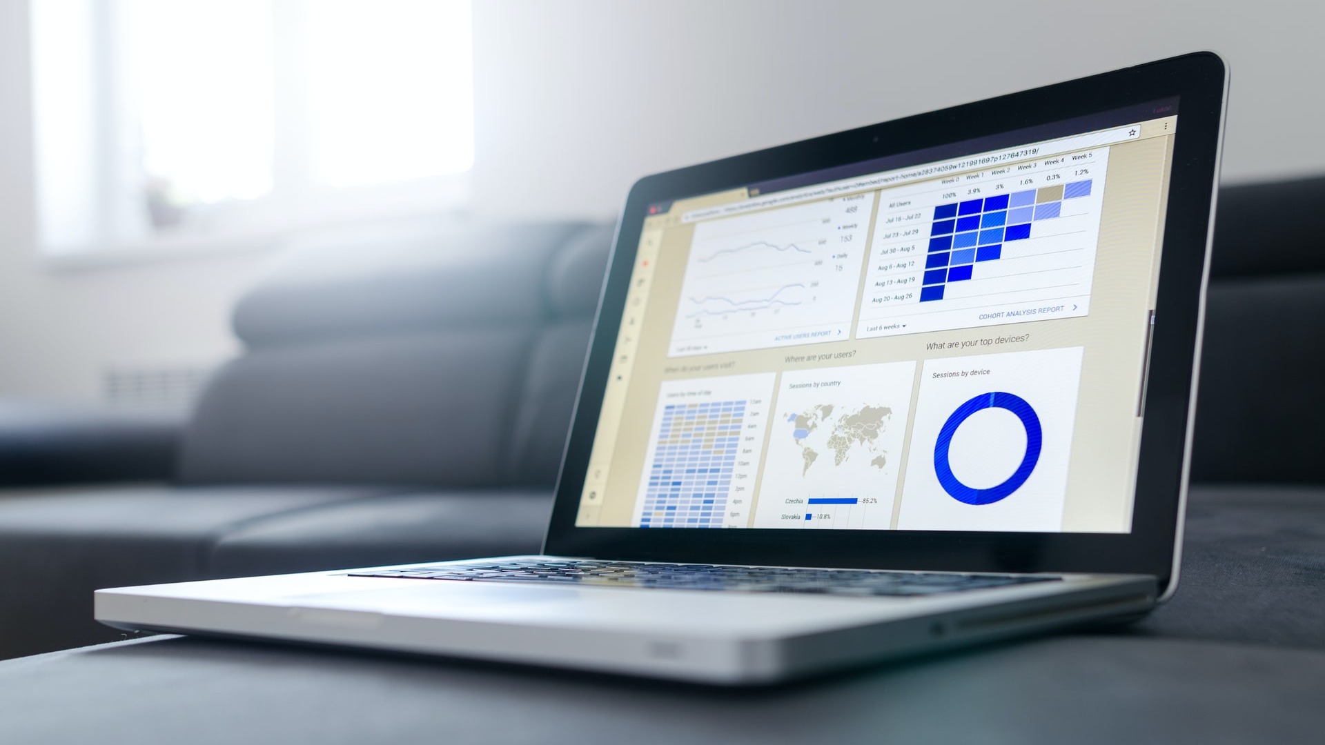 Image of an open laptop displaying analytics and a world map. 