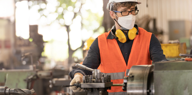 workers factory man wearing face mask and working at heavy machine. Safety protection of air pollution smoke dust and disease virus Covid 19 Image