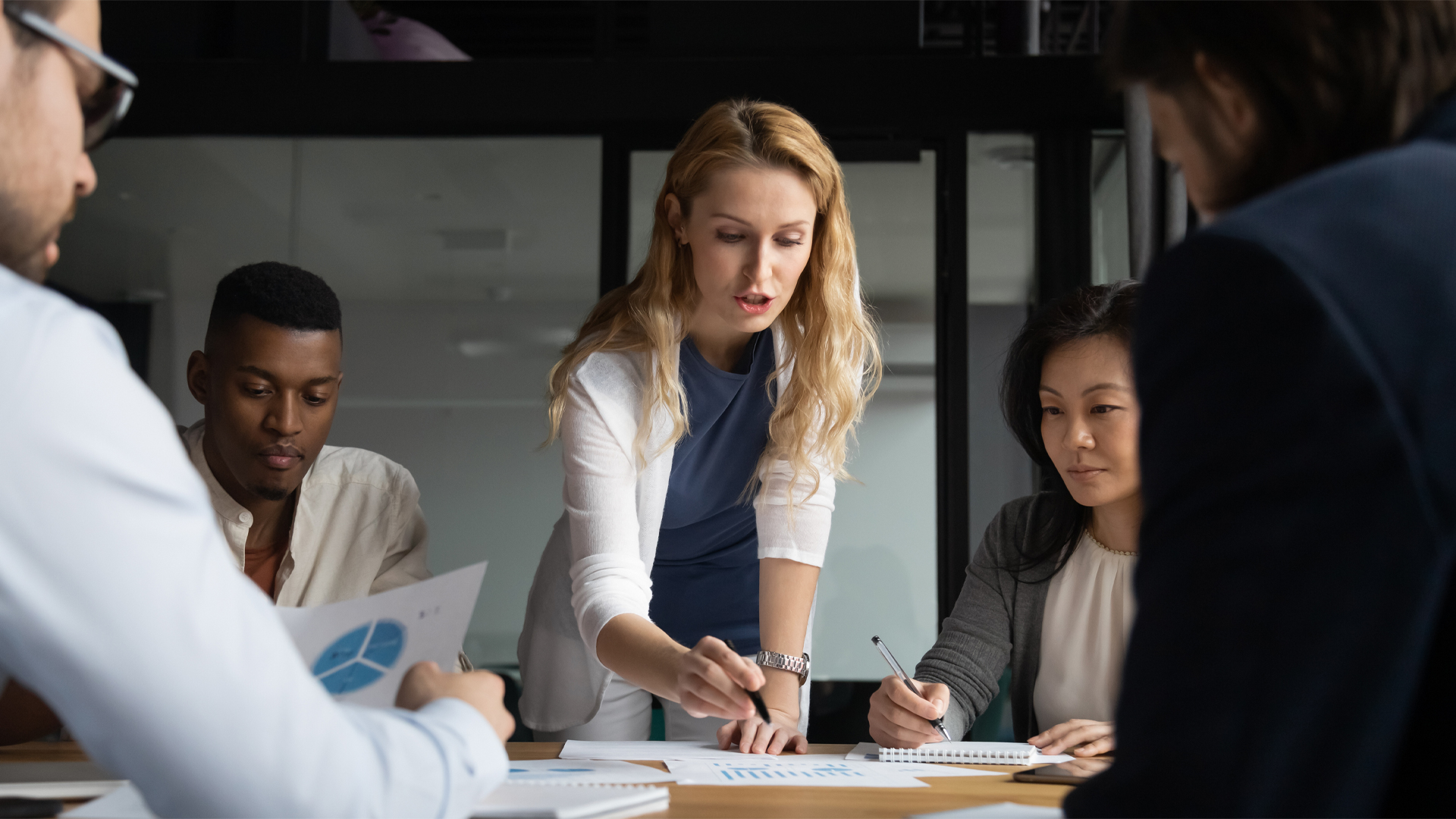 Young businesswoman explaining research results in graphs to colleagues Image for Hero Box