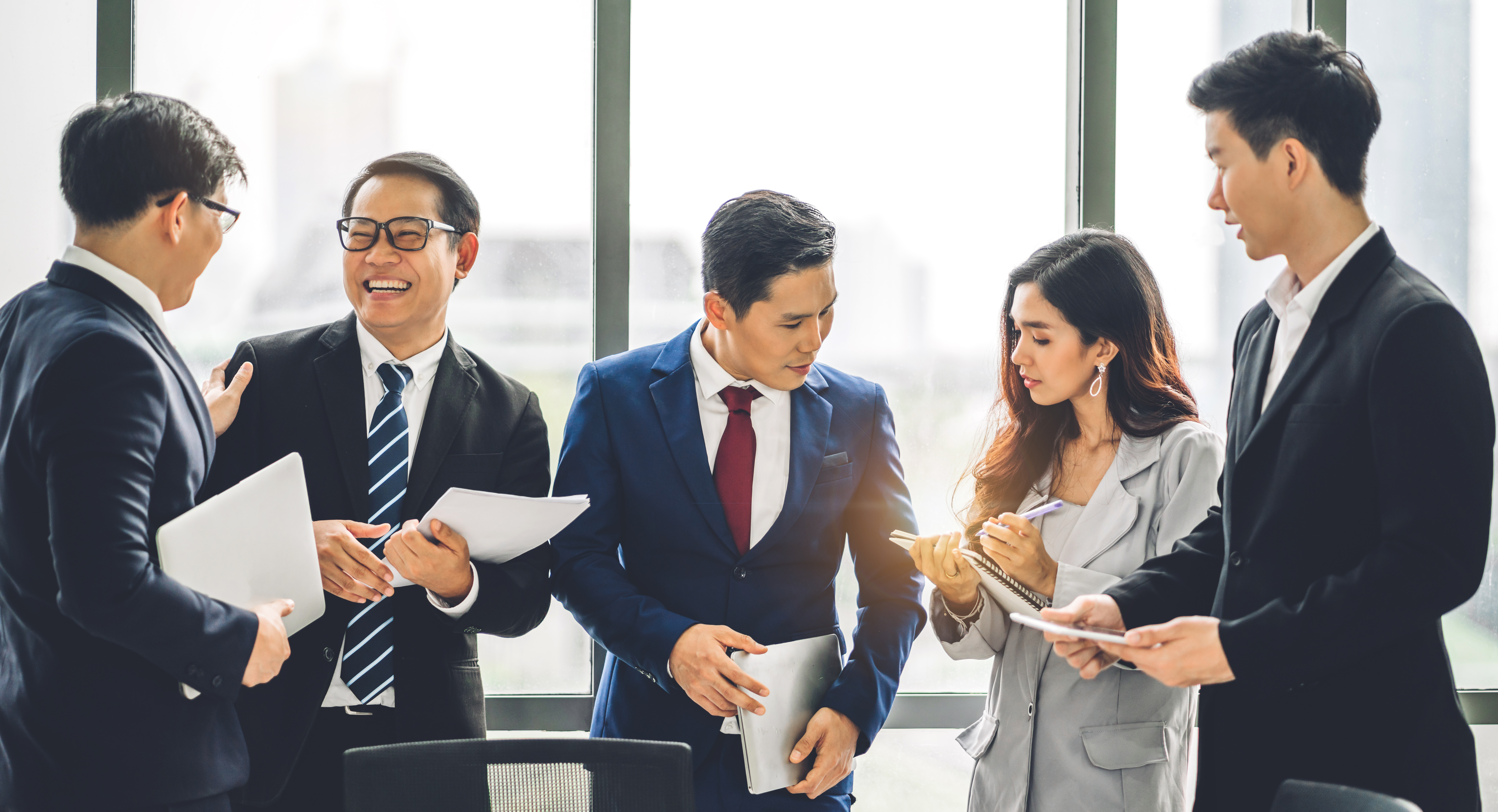 Five business people of Asian descent meeting