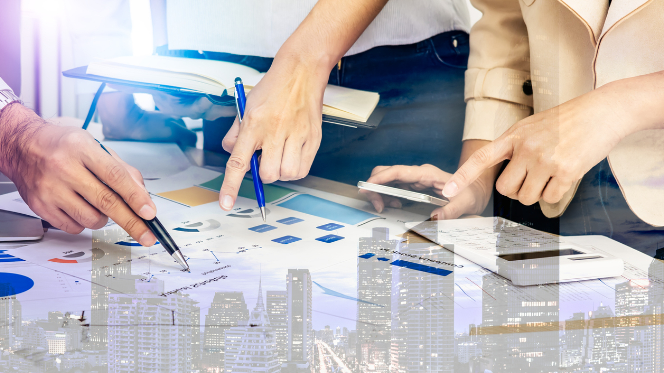 Image of people pointing to graphs and charts in a business meeting.