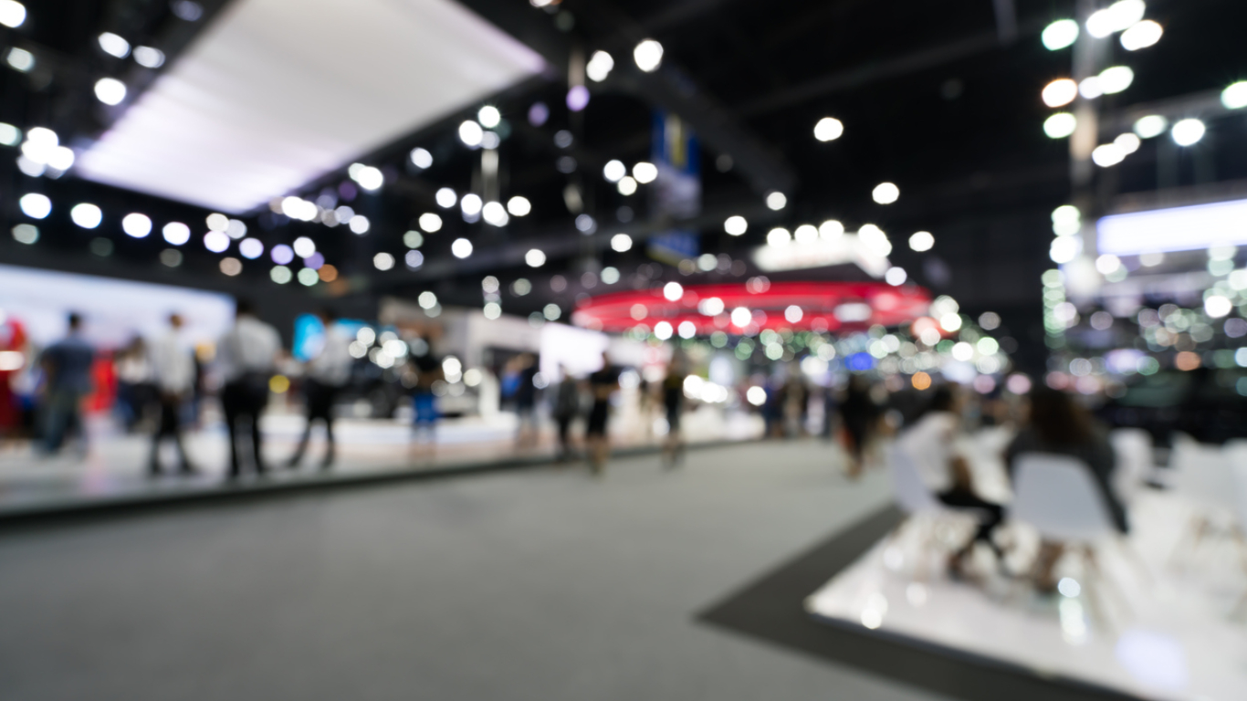Blurred image of an investment trade show floor during an event.