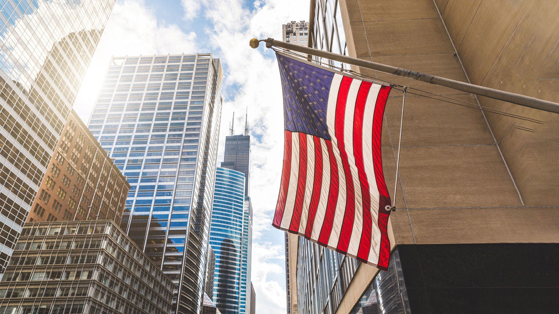 U.S. flag waving next to Skyscrapers in Chicago Illinois