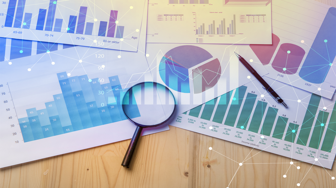 Market Research Graphs on paper and Magnifying Glass