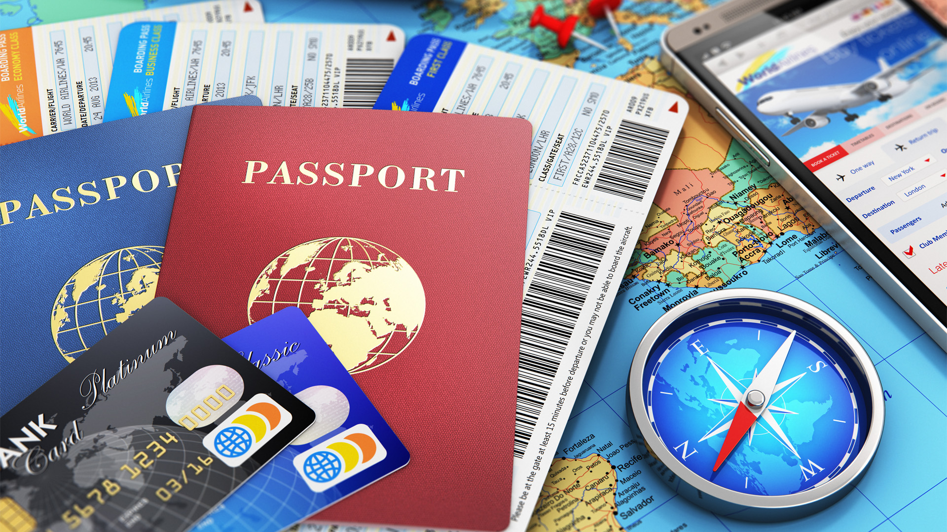 Travel picture with passports, airline tickets, cell phone with travel instructions and a map background and compass.