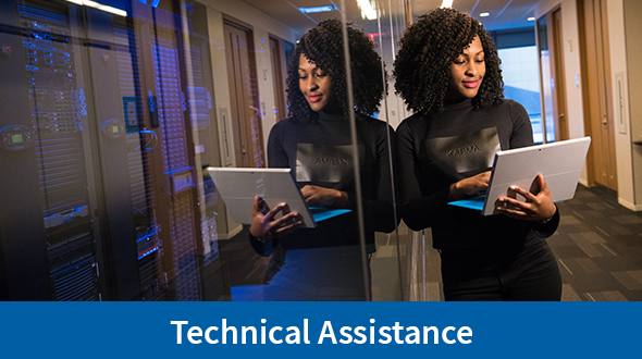 Technical Assistance Heading, woman with computer standing at server room