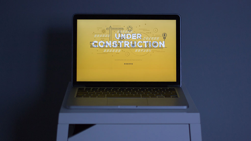 A laptop reading under-construction across the screen