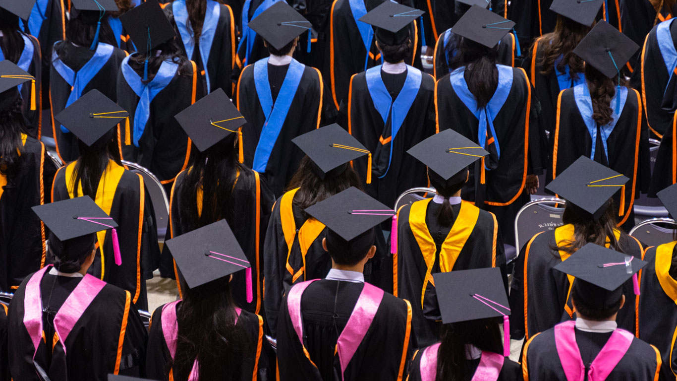 Image of graduates in black gowns from the back