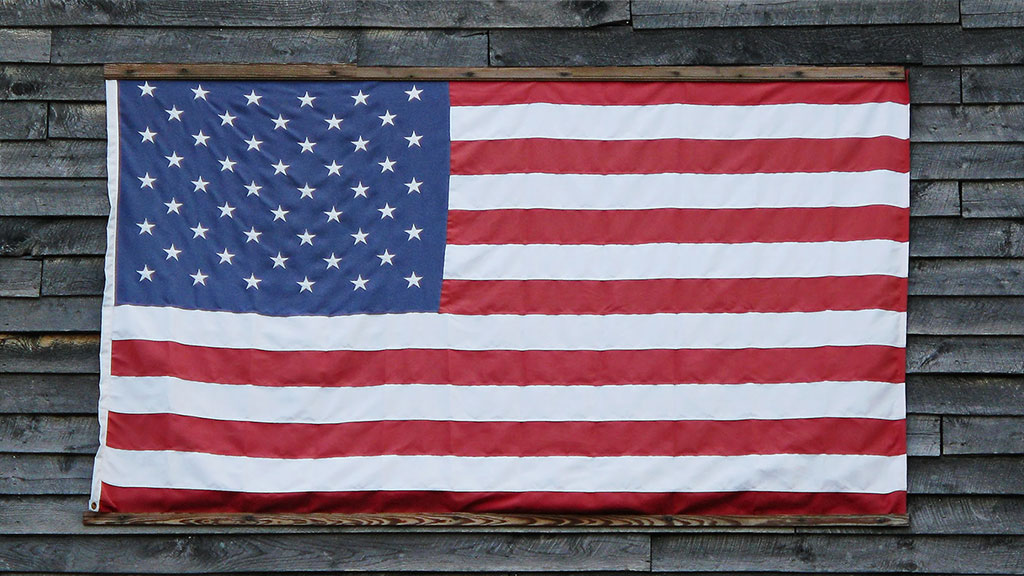 American Flag handing on side of wooden building
