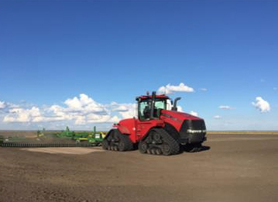 Red tractor plowing a field during the daytime