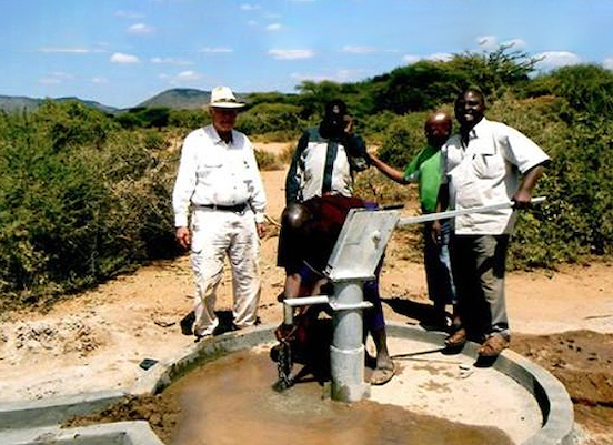 Africans standing next to Americans right beside a well drill bit