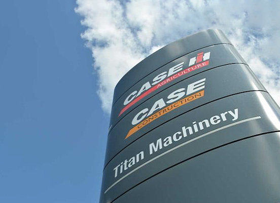 large CASE Titan Machinery street sign with clouds overhead 