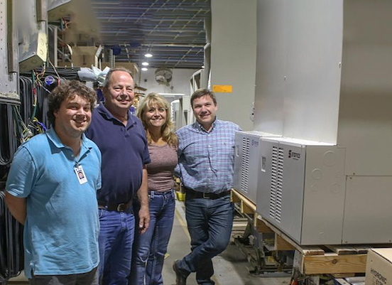 Polish company employees standing next to company heaters in factory