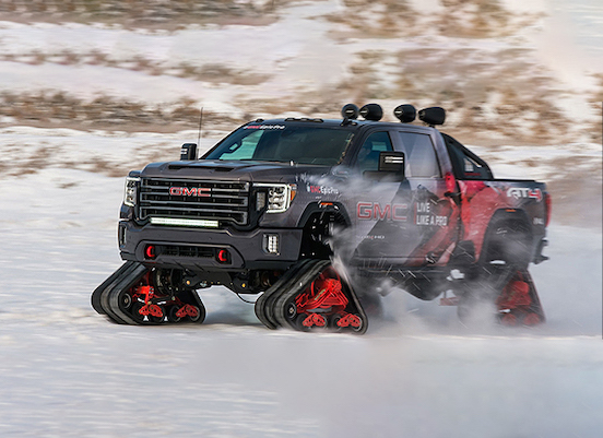 Large black sport winter truck traveling across the snow fast
