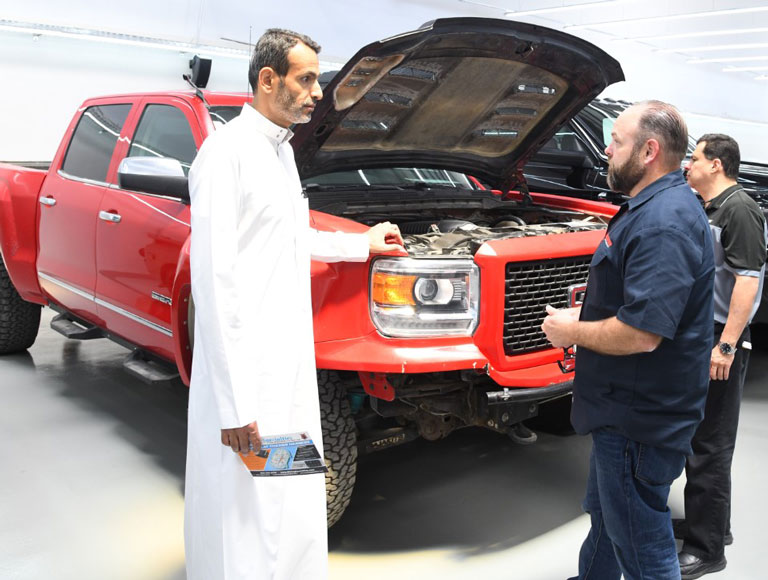 Men talking beside truck with hood up