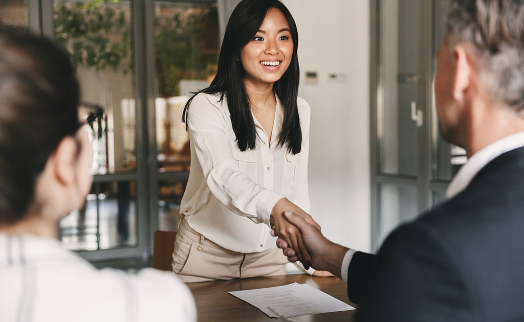 woman shaking hands with man at interview