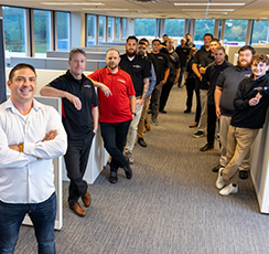 A group of around 10 businessmen in black and khaki pants