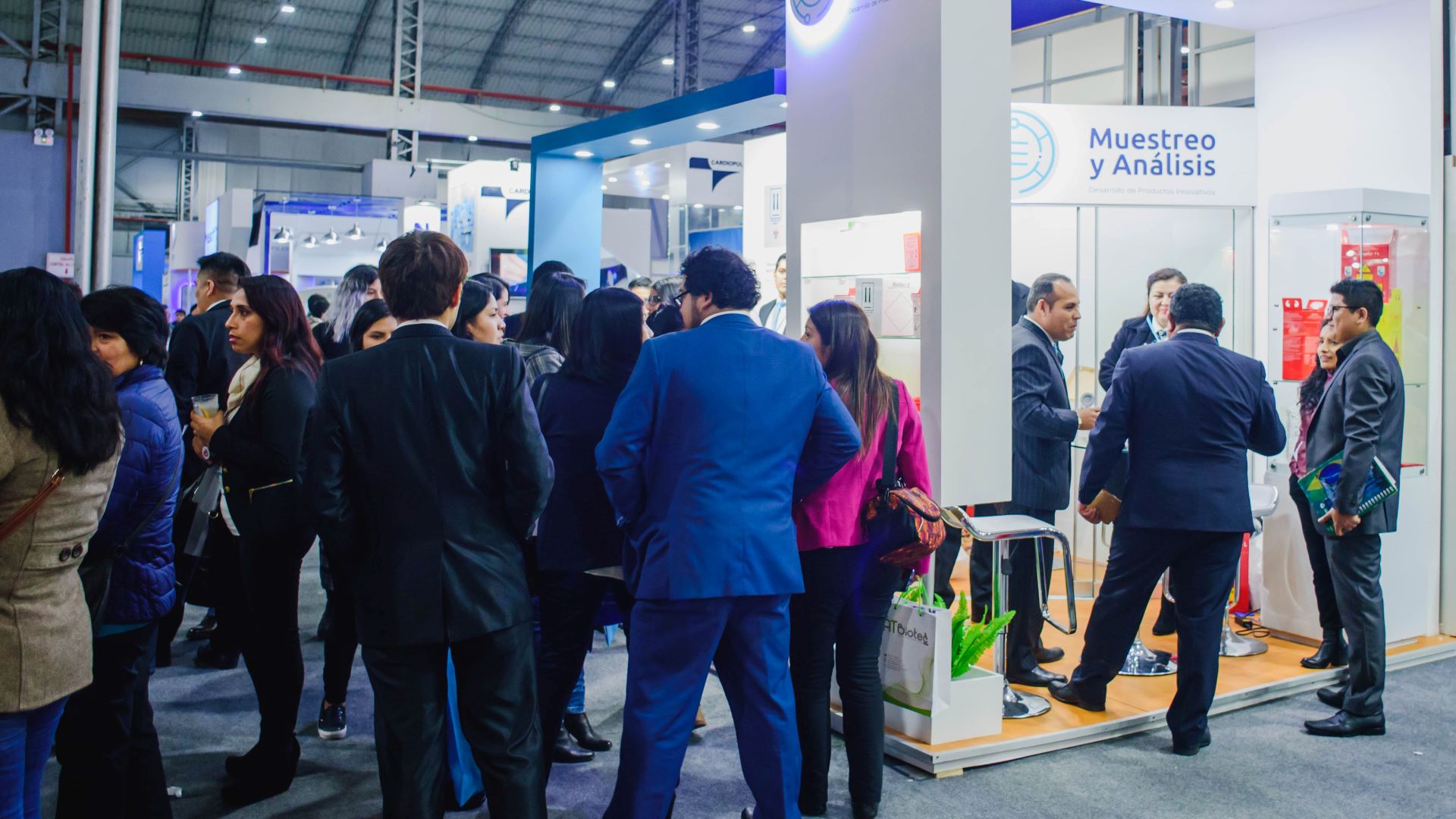 People gathering at a booth at Tecnosalud