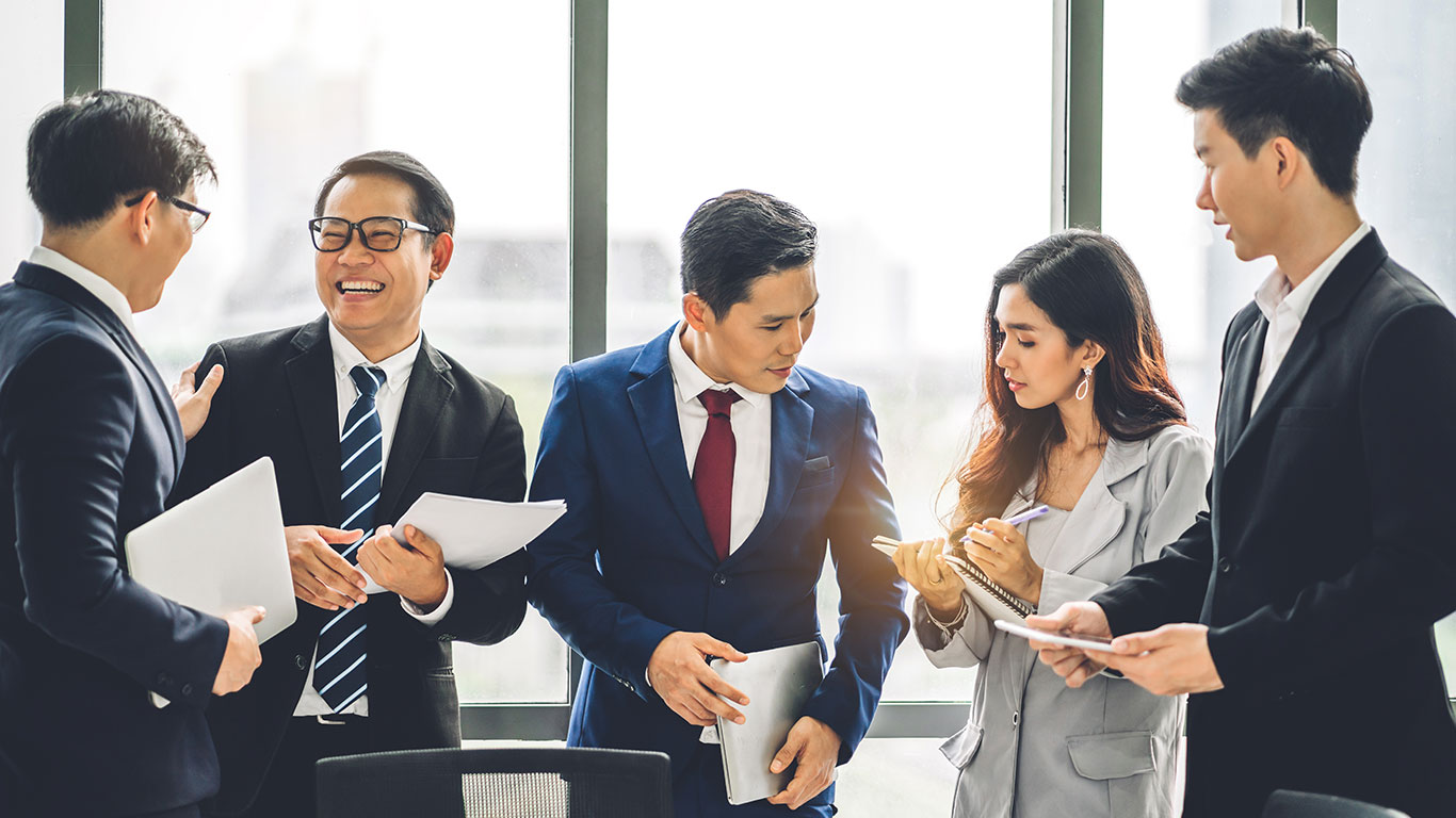 Five business people of Asian descent meeting