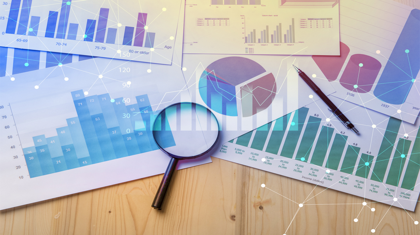 Market research graphs on paper and a magnifying glass