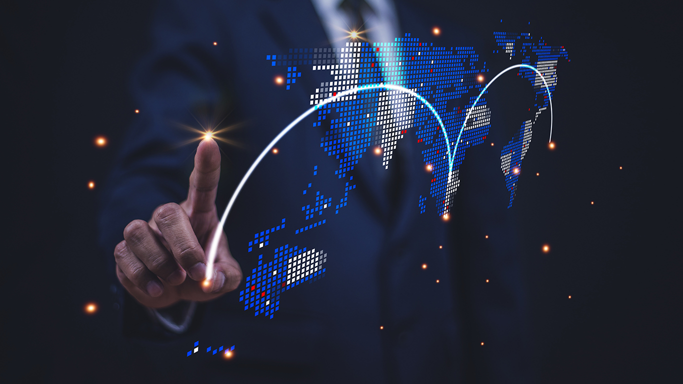 An anonymous man in a suit points to a map with major cities highlighted and connected