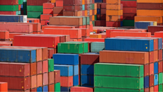 A photograph of dozens of colorful stacked shipping containers.