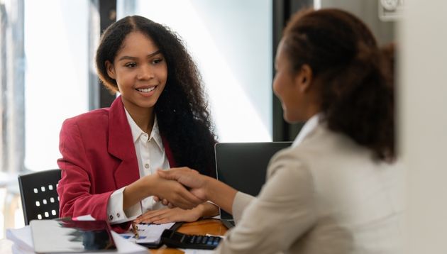 Business people shaking hands over a desk.