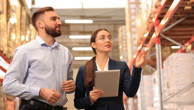 A photograph of people looking over stock in warehouse.