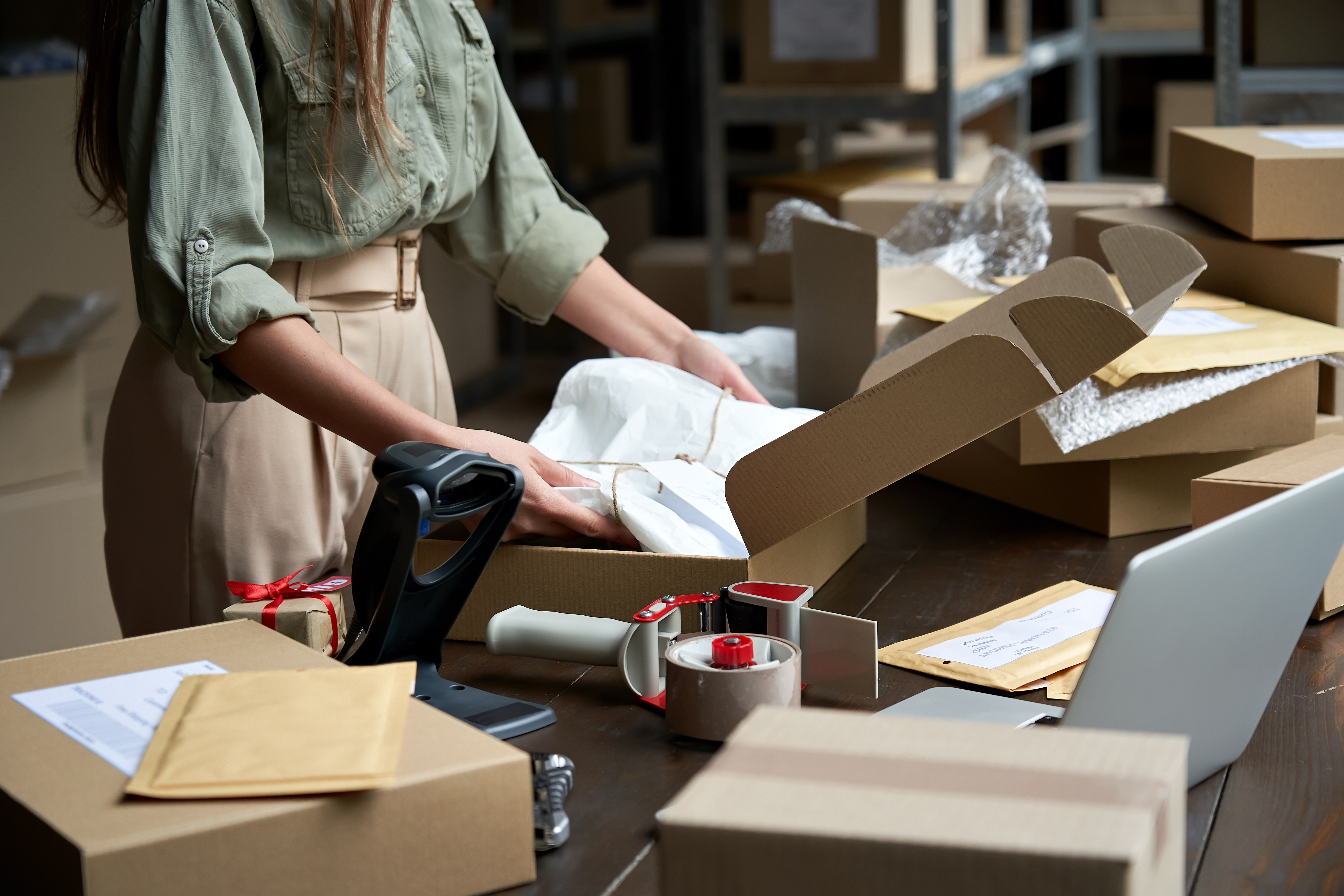 Close up of a woman packing shipping boxes