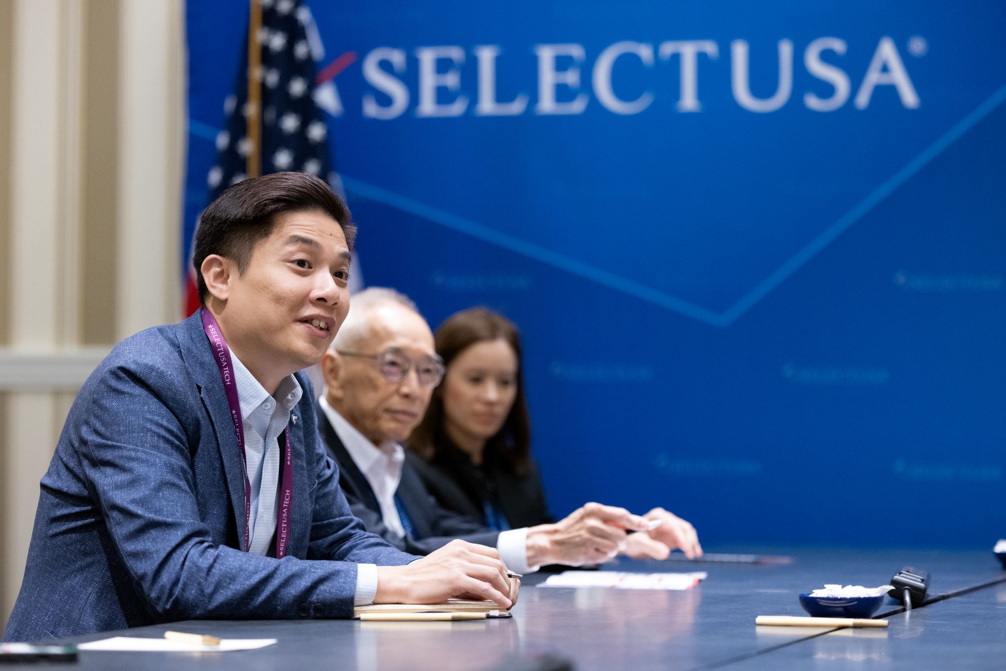 Three people are seated at a table during a SelectUSA event.