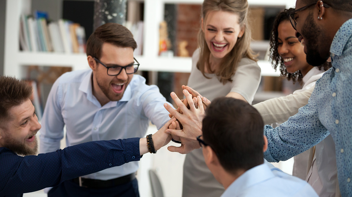 Six people giving high five in an office