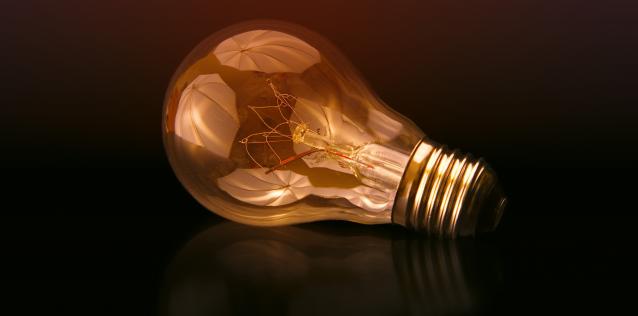 Illuminated Lightbulb on side with dark background