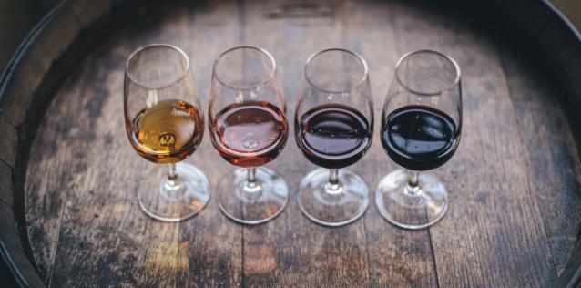 Flight of wine in small glasses on wine barrel