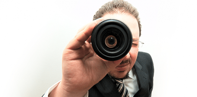 A man looking through a monocular with a white background