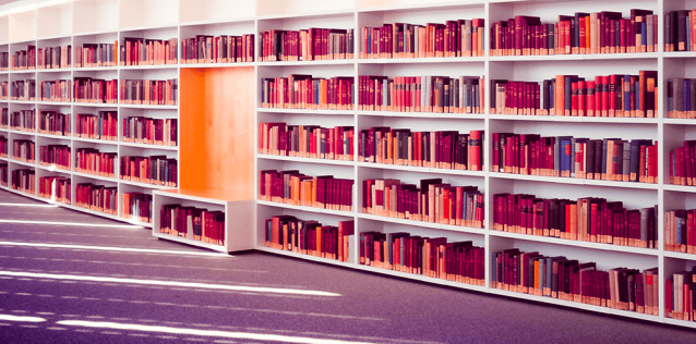 a collection of books on a curved, white bookshelf