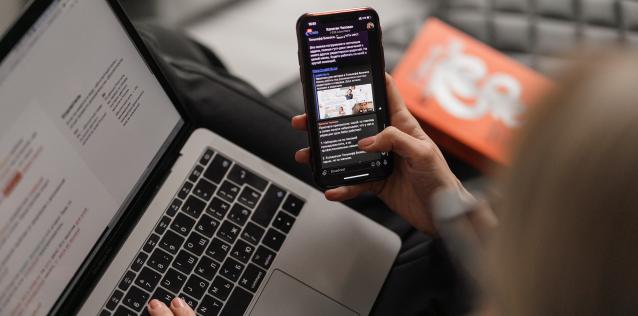 Person holding phone and computer