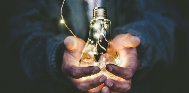 two hands holding a lightbulb