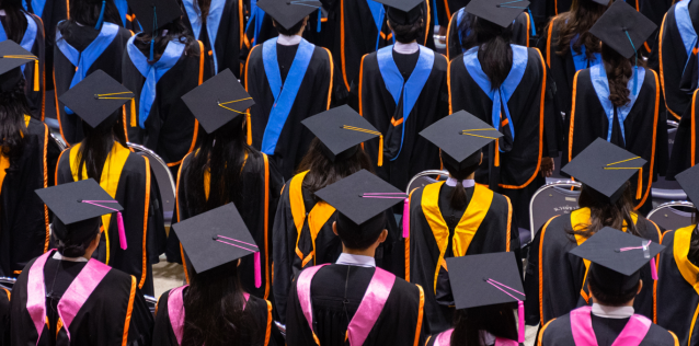Image of graduates in black gowns from the back