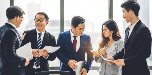 Five business people of Asian descent meeting