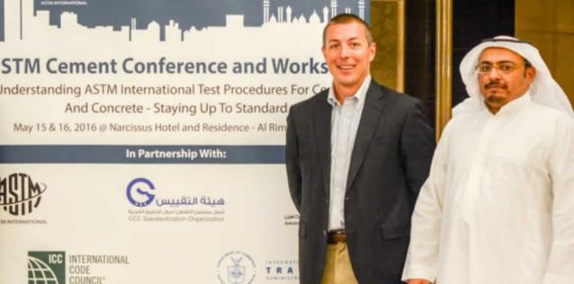 Commercial Specialist standing aside Saudi Arabian Partner in front of project sign