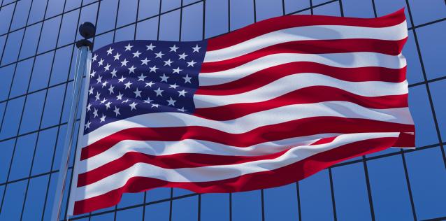 United States of America flag on skyscraper building background.