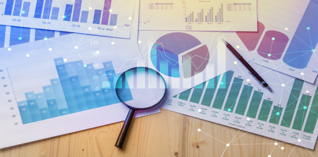 Market Research Graphs on paper and Magnifying Glass